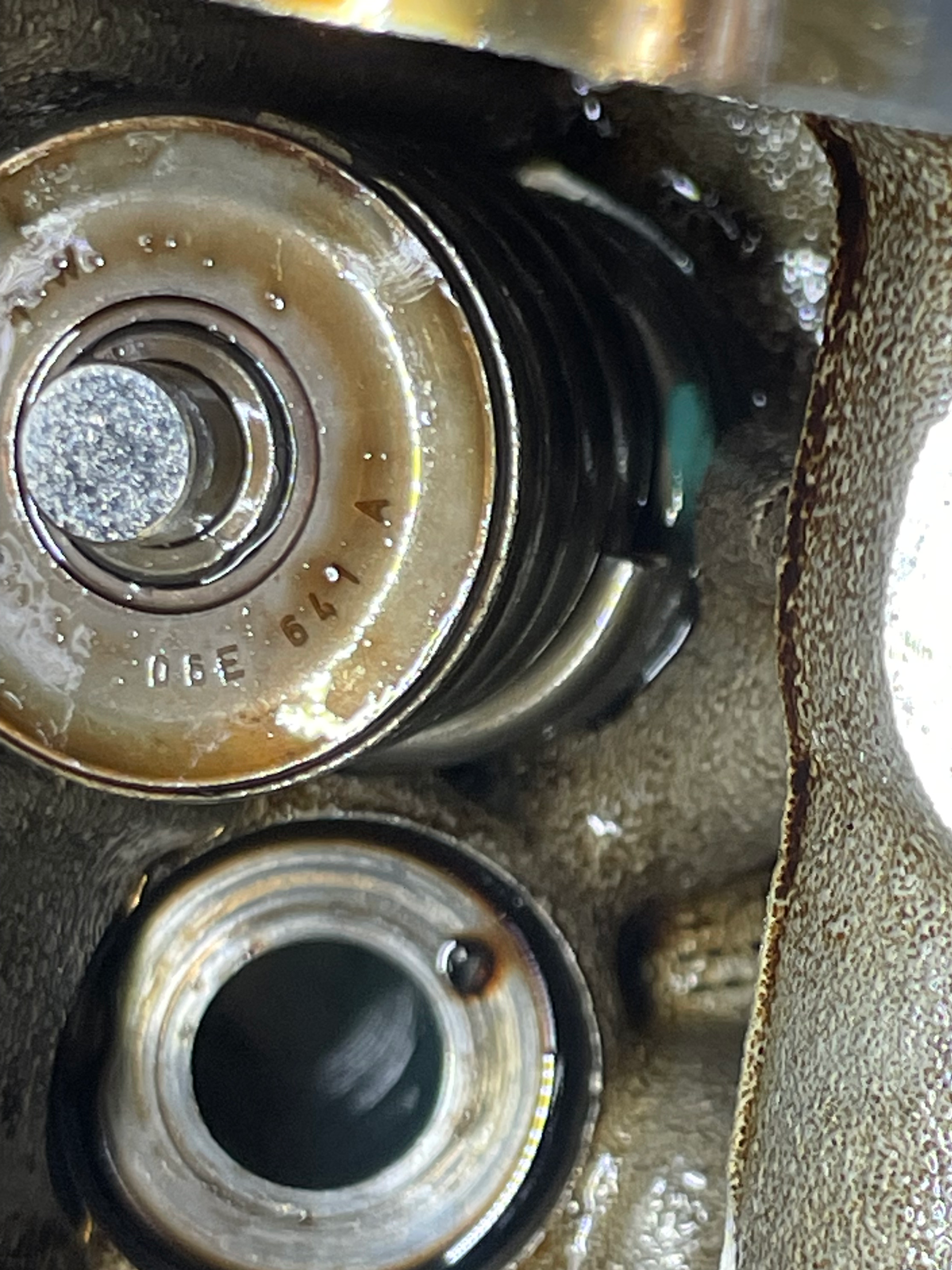 Valve spring still installed in the head during diagnosis; the defect is subtle and easy to miss